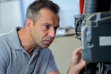 man inspecting a car engine