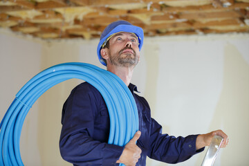 male builder holding a hose pipe insulation