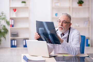 Old male doctor radiologist working in the clinic