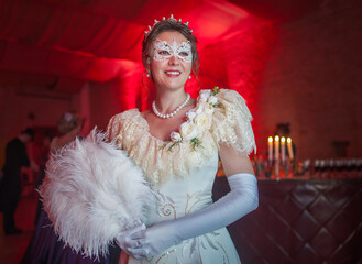 Woman in 19th century dress with candles at the royal ball in the castle