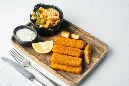 Fish fingers with French fries potatoes, on wooden tray, on white background , with copyspace  and space for text