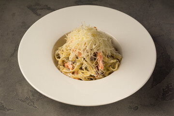 Traditional italian pasta with salmon pieces and parmesan cheese