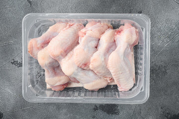 Fresh chicken wings package, on gray stone background, top view flat lay