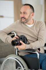 male photographer on wheelchair holding camera