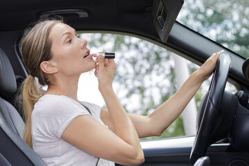 Obraz na płótnie Canvas woman applying make-up in car