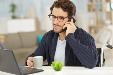 delighted man sitting on the wheelchair working from home