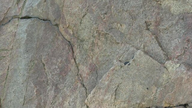Mining granite in the quarry. Cracked granite stones. Close-up of solid rock with cracks