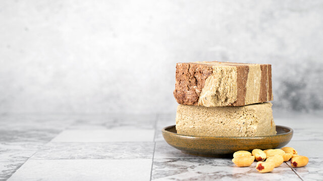 Tasty eastern sweet dessert halva from sunflower seeds, cocoa and tahini on gray background.Traditional dessert confection in Middle East, Balkans and west Asia.Horizontal.Copy space