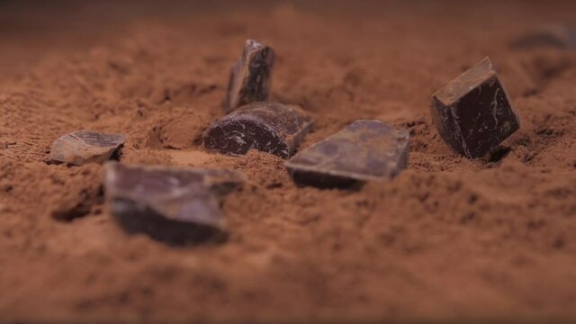 raw chocolate falling into cacoa powder slow motion