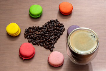 Still life with macaroons, espresso cup and coffee beans heart