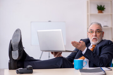 Old male employee working in the office