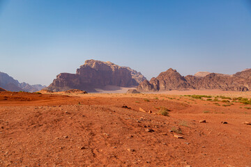 Fototapeta na wymiar Red sand, huge rocky mountains and clear blue sky in Wadi Rum desert, Middle East, Jordan.