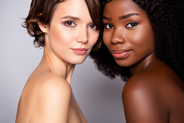 Portrait of two attractive nude women bonding pure smooth clear perfect skin complexion isolated...