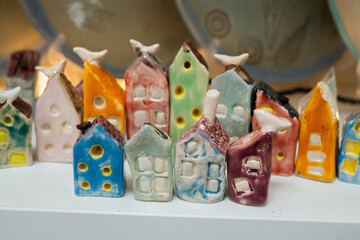 Colorful handmade ceramic houses of clay with glaze in the pottery workshop