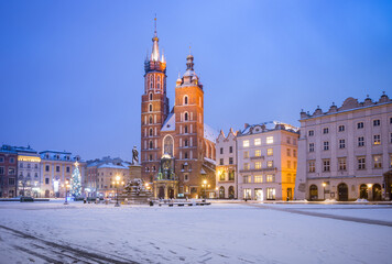 Fototapeta na wymiar St Mary's church on snow covered Main Square in winter Krakow, illuminated in the night