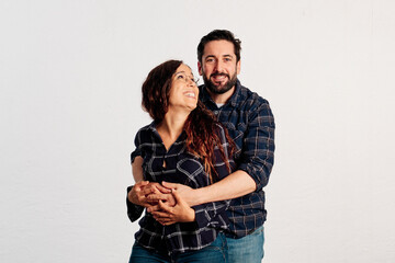 An adult couple in plaid shirts showing thumbs up to the camera and smiling against a white background - 463493007