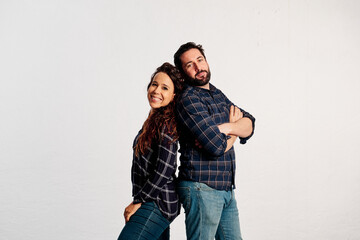An adult couple in plaid shirts showing thumbs up to the camera and smiling against a white background - 463493019
