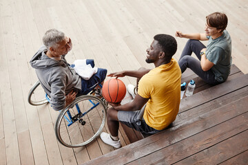 High angle view of people laughing while talking about basketball match while sitting on the bench