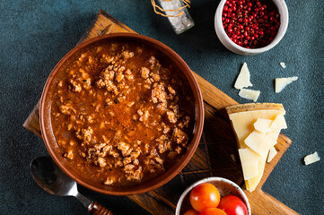 classic italian bolognese sauce with ingredients on blue background. Bolognese sauce top view. culinary background with space for text. Pasta bolognese. Italian lasagna
