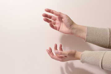 two female hands hold any object on a beige background. Product presentation, cosmetics