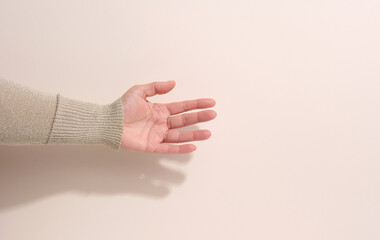 female teen hand to hold something on a beige background. Advertising and product promotion