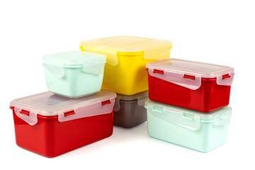 Multicolored plastic lunch boxes folded at corner on white background, side view