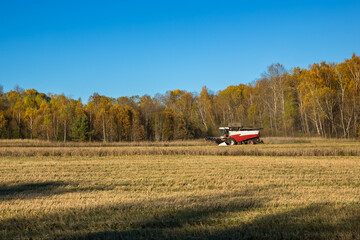 Fototapeta na wymiar Combine harvester harvesting in a field in autumn