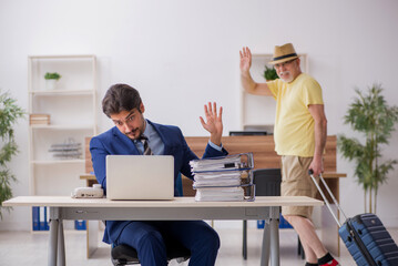Old boss and young male employee in summer vacation concept