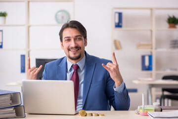 Young man earning money via Internet in cryptocurrency concept