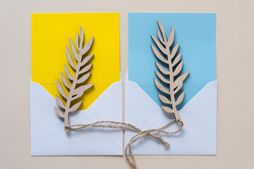 two leaf tags on blue and yellow cards with envelopes