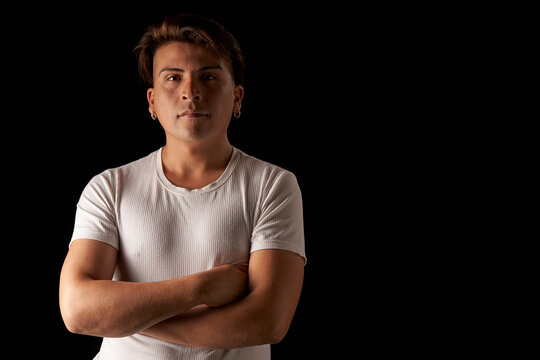 portrait latin man with crossed arms in studio black background