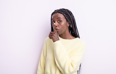black pretty woman asking for silence and quiet, gesturing with finger in front of mouth, saying...