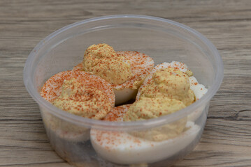 Generous portion side order of deviled eggs in a clear plastic bowl to compliment your meal