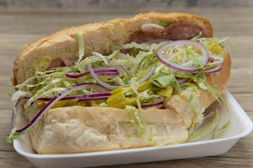 Handmade from fresh ingredients Italian sandwich with salame, lettuce, onion, tomatoes, and pepperoncinis in a oven baked bun