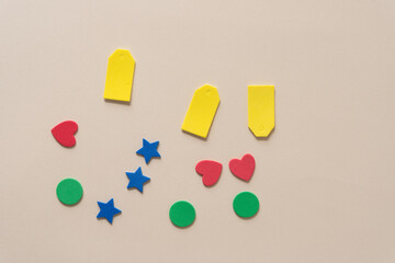 foam shapes (tags, hearts, stars, circles) on beige paper