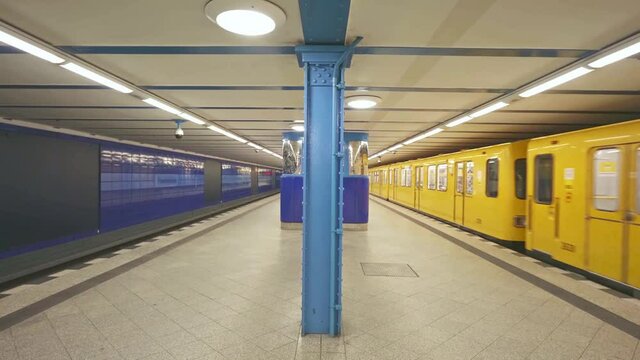 Metro subway station in Berlin. U-Bahn is an underground metro in Germany. Yellow train at platform.