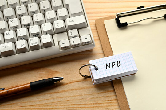 There is a word book with the word of NPB which is an abbreviation for National Printing Bureau on the desk with a pen and a keyboard.