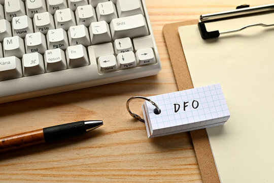 There is a word book with the word of DFO which is an abbreviation for Data Feed Optimization on the desk with a pen and a keyboard.