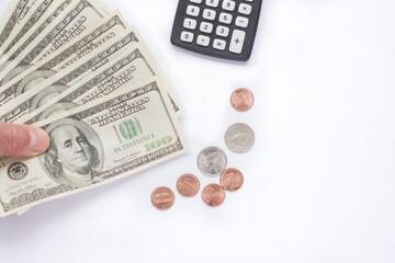 Fototapeta premium Middle age Man holding dollar bills on white background with dollar coins and calculator . Copy Space concept