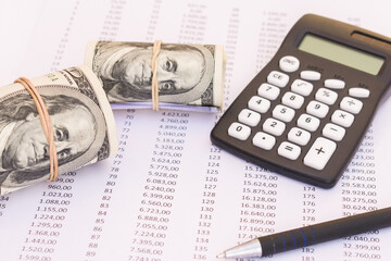 One hundred dollar bills bundles with Calculator and pen on financial paper. Top view of business concept on background with copy space