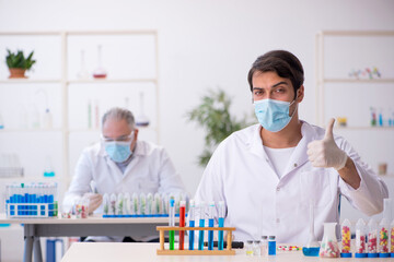 Two male chemists in drugs synthesis concept at the lab