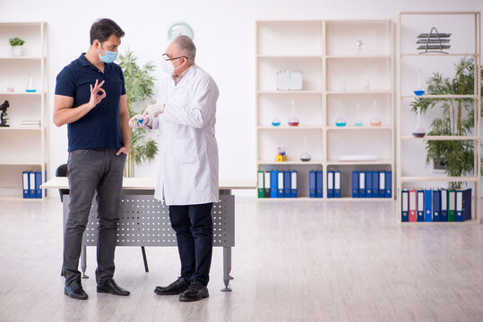Young male patient visiting old male doctor in vaccination conce