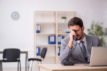 Obraz premium Young male employee and too much work in the office