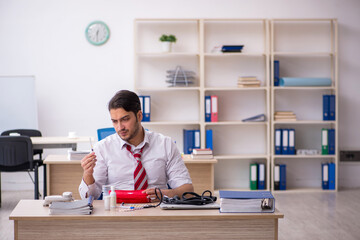 Young male employee suffering at workplace