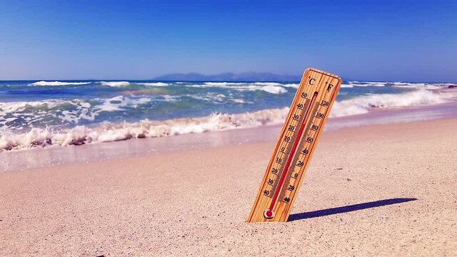 A thermometer on a hot summer day on the beach is a reminder of global warming