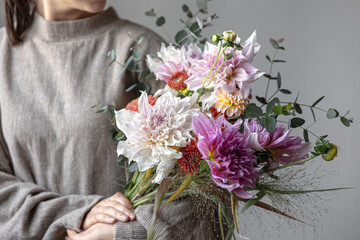 Close-up of a bright festive bouquet with chrysanthemums in female hands.
