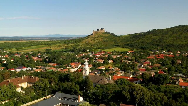 Wide rotating drone shot of the Boldogkő Castle in Hungary and the town below