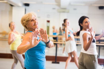 Fotobehang Women of different ages dancing together during their group training. © JackF