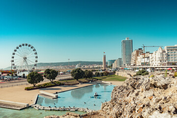 Intentionally blurred stone overlooking the town and clock tower of Figueira da Foz, PORTUGAL