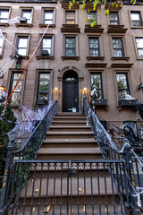 A townhouse with Halloween pumpkins and Halloween decorations in the evening on a city street. Trick or treat..